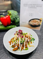 Mongolisches Rindfleisch mit knackigem Gemüse, Sprossen und Gewürzreis ist auf einem weißem Teller angerichtet in der Kantine Berenberg Privatbank.