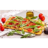 Die neuen KuchenMeister Flammkuchenböden im Gastronorm-Format Flatbread topped with arugula, cherry tomatoes, and mushrooms on a white platter, with olive oil and tomatoes nearby.